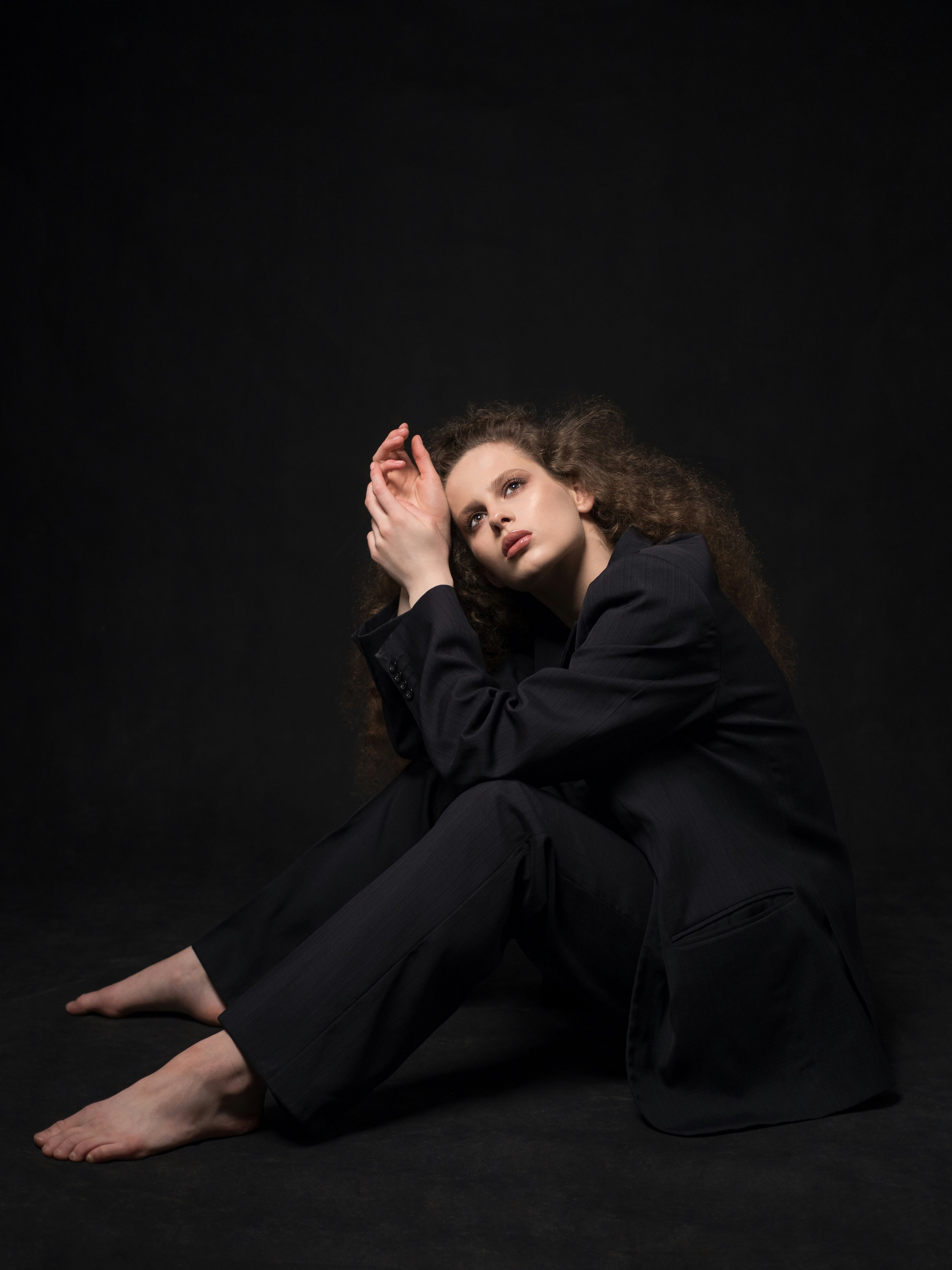 woman in black leather jacket and black pants sitting on floor